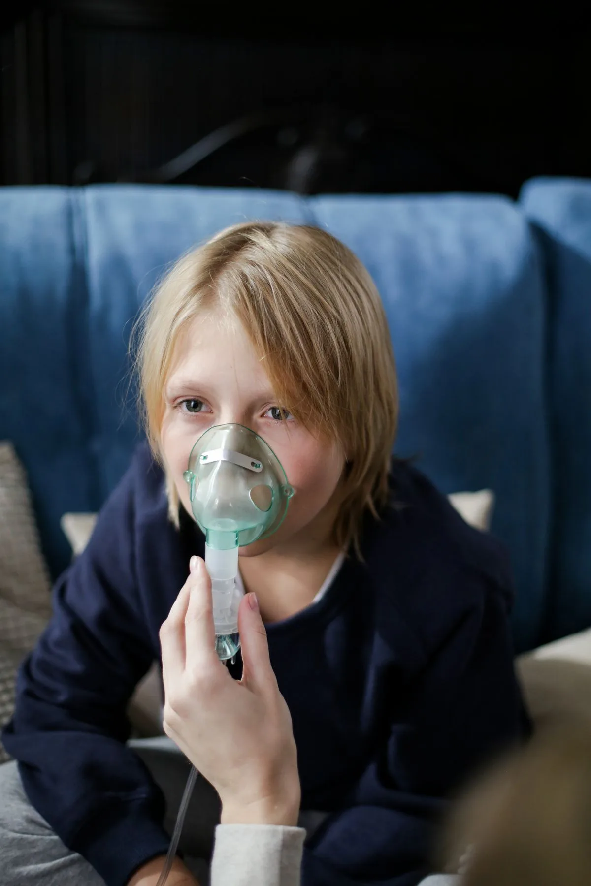 Criança usando máscara de nebulização sentada em casa