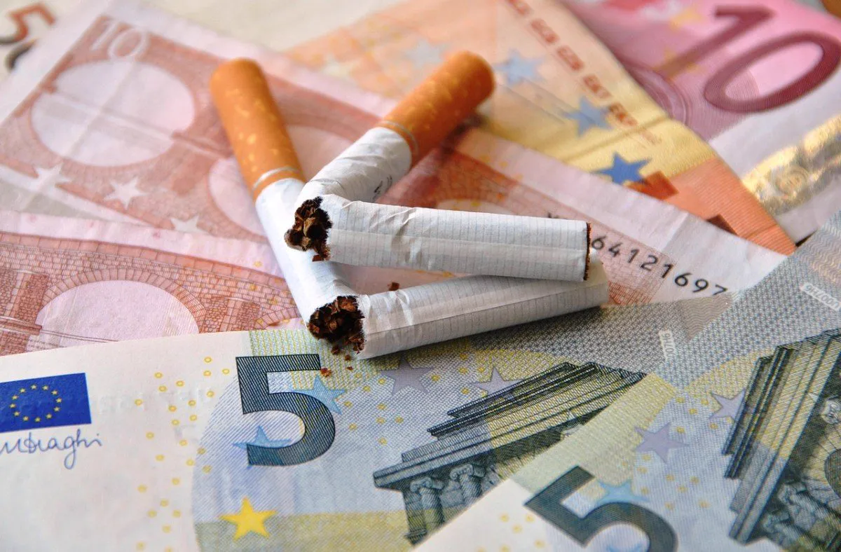 Cigarros apagados sobre cédulas de dinheiro