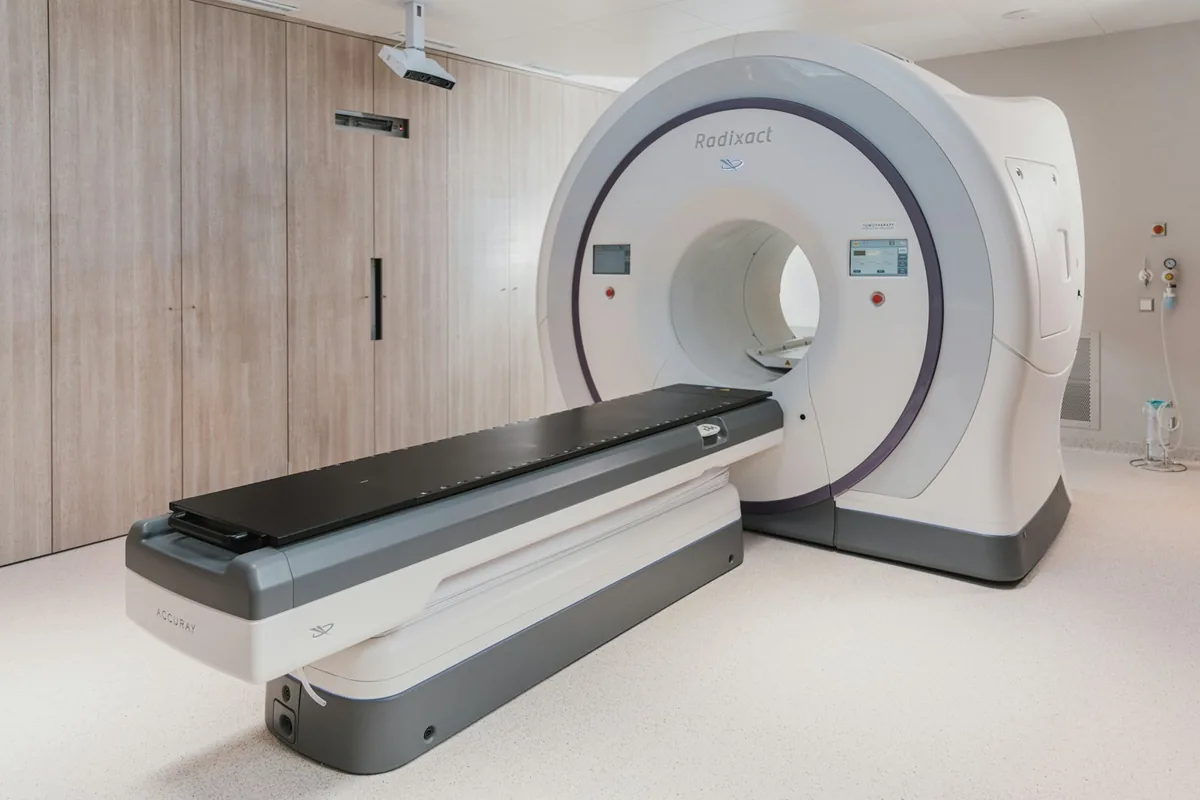 Aparelho de imagem médica com mesa deslizante em sala clara